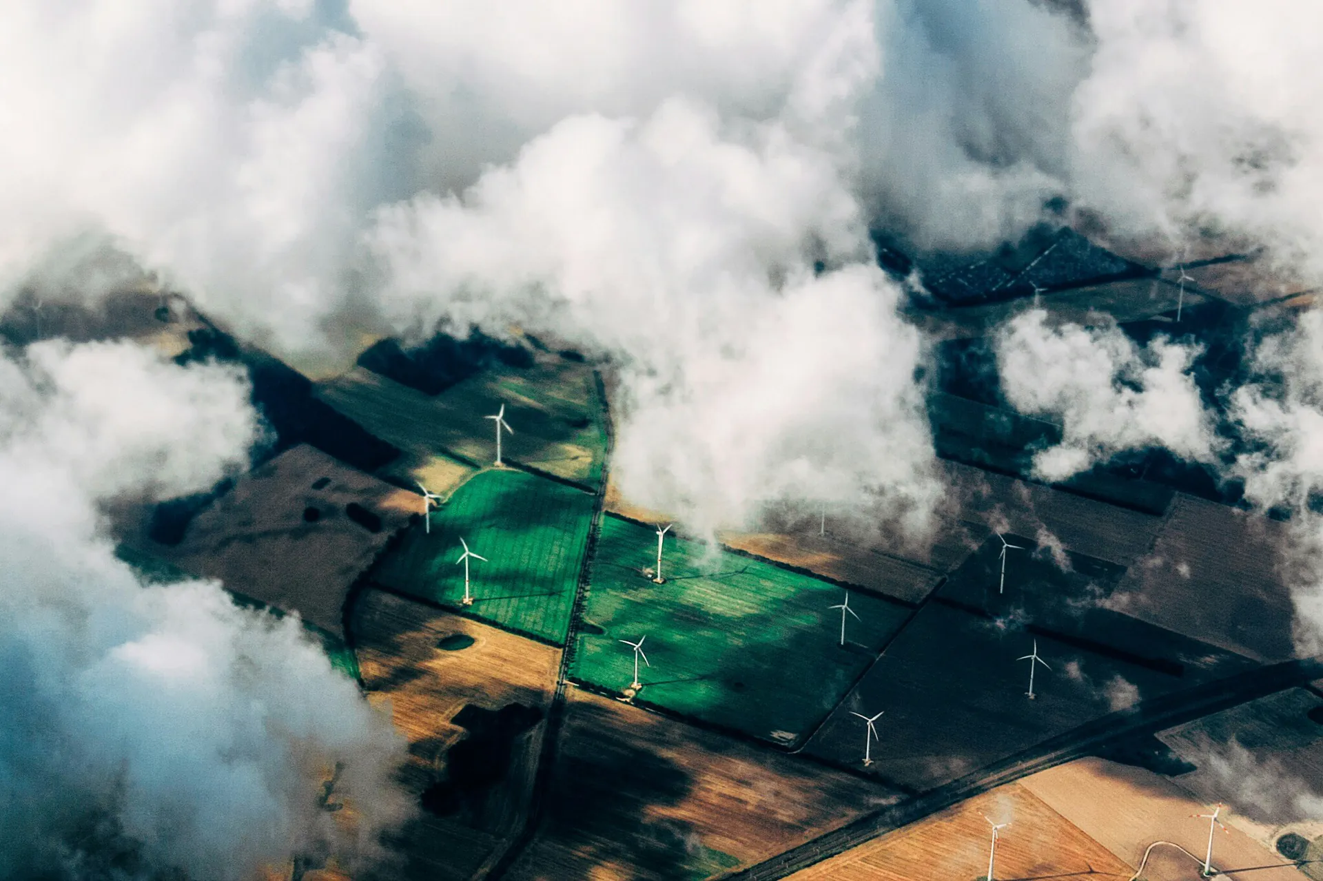 Luftaufnahme von Windkraftanlagen Luftaufnahme von Windkraftanlagen auf landwirtschaftlichen Flächen zwischen Wolken