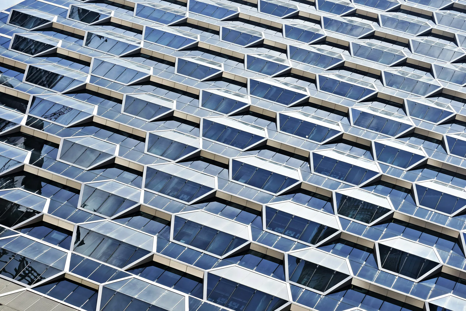 Moderne Gebäudefassade mit geometrischem Design Moderne Gebäudefassade mit geometrischem Glasdesign und futuristischer Architektur