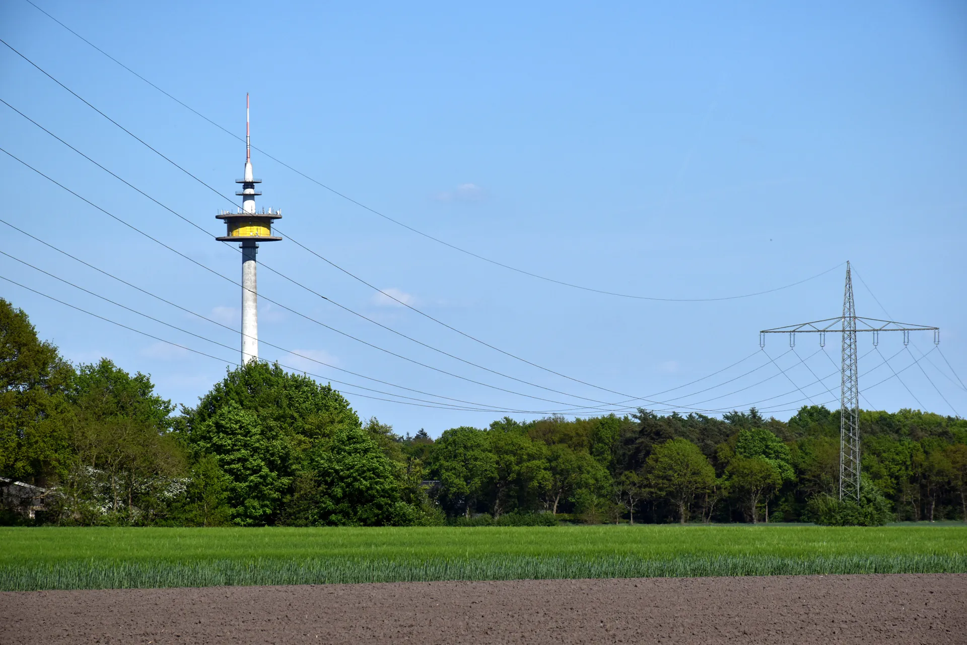High-voltage power line over agricultural land with electricity pylon